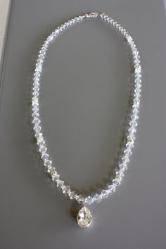 This will go well with a beaded gown to pick up those crystal accents.  It is very reflective and will sparkle throughout your special day.  This bridal necklace is made of Swarovski crystals and a large tear drop Swarovski rhinestone pendant.  It can be made to any length but this one measures 17 inches. Check out the matching Earrings:  https://www.etsy.com/listing/92769395/rhinestone-and-crystal-bridal-earrings  Check out the matching Bracelet https://www.etsy.com/listing/92769908/simple-crystal-and-rhinestone-bridal White Rhinestone Bridal Necklace For Anniversary, White Sparkling Crystal Bridal Necklace, Sparkling White Necklace For Wedding, Sparkling White Wedding Necklace, White Crystal Rhinestone Necklace For Wedding, White Sparkling Bridal Necklace For Anniversary, Sparkling White Bridal Necklace For Anniversary, White Rhinestone Necklace With Sparkling Crystal Stones, White Rhinestone Wedding Necklace With Sparkling Stones