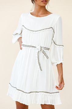 White tunic style dress  Partially lined  Three-quarter sleeves  Removable waist tie  Pom-pom trim detail  Non stretchy   Breeze through your day in our boho-chic Marionette dress. It's super versatile and we are loving the pom-pom trim detail. Perfect for lunch dates with your girls paired with ankle boots and a felt hat or dress it up with tan mules and some gold hoops for a chic look we are loving. Flowy Dresses With 3/4 Sleeves For Vacation, Summer Boho Beach Dress With 3/4 Sleeves, Summer Boho Dress With 3/4 Sleeves For Beach, Summer Boho Dress For Beach With 3/4 Sleeves, Summer Beach Boho Dress With 3/4 Sleeves, Summer Boho Dress With 3/4 Sleeves For Vacation, Boho Dress With 3/4 Sleeves For Summer Vacation, Summer Vacation Boho Dress With 3/4 Sleeves, Bohemian Dress With 3/4 Sleeves For Brunch