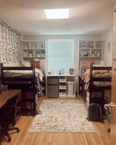 a bedroom with bunk beds and desks in the corner, on top of a hard wood floor