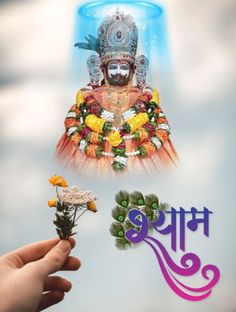 a person holding flowers in front of a poster with an image of the hindu god