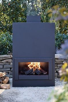 an outdoor fireplace with logs in the foreground