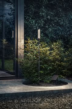 a street light sitting in front of a building next to a tree and shrubbery