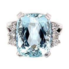 an aqua and white topazte ring with diamonds on the sides, set in 18k white gold