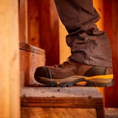 a man standing on top of a wooden step with his foot up to the ground