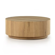 a round wooden table sitting on top of a white floor