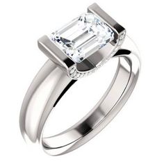 an emerald cut diamond engagement ring on a white background