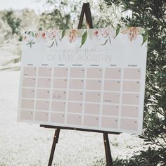 a sign that is on top of a easel in front of some grass and trees