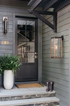 a pair of boots are sitting on the front steps next to a potted plant