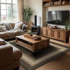 a living room filled with furniture and a flat screen tv on top of a wooden table