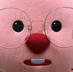 a pink stuffed animal with glasses on it's face