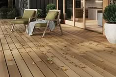 an outdoor deck with chairs and potted plants