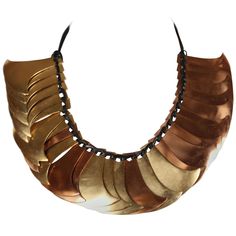 Sculptural brass and gilt metal pieces make up this dramatic collar from Yves Saint Laurent as seen on the spring 1983 runway. This is a very rare and unique piece. Beautiful patina to metal. Strung on cord with beads at ends. Approximate measurements: each piece is approximately 2.5" by 2.5" and end to end 34". Numbered 070/600. Condition is very good. Copper Necklace 1stdibs, Dramatic Collar, Ysl Vintage, Kendall Jenner Chanel, Runway Necklace, 25 October, Number Necklace, Tooth Necklace, Kendall And Kylie Jenner