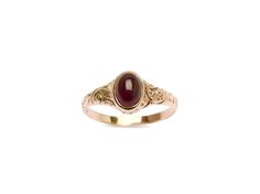 Check out this darling garnet cab, set into an etched rosy gold 10k band. This handsome ring features a swirling design that arcs all along a tapered band. The center stone features a deep merlot garnet. There is an inscription on the inside of the ring that is hard to make out but is likely a commemorative dedication of some kind. The kind of quintessential Victorian ring everyone is on the hunt for- a classic!. Classic Oval Engraved Ruby Ring, Elegant 14k Gold Cabochon Birthstone Ring, Elegant Engraved Ring With Oval Cabochon For Formal Occasions, Elegant Engraved Oval Cabochon Ring For Formal Occasions, Elegant Formal Engraved Oval Cabochon Ring, Elegant Oval Ruby Ring With Intaglio, Heirloom Engraved Ruby Ring For Formal Occasions, Elegant Round Ruby Ring With Intaglio Detail, Elegant Round Ruby Intaglio Ring