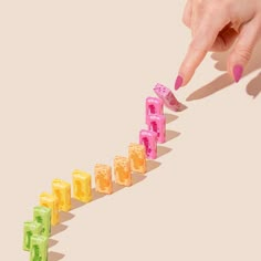 a woman's hand reaching for candy cubes in the shape of an arrow