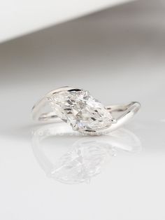 an oval cut diamond ring on a white surface