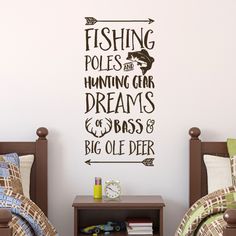 two beds in a room with a wall sticker on the wall above them that says fishing poles and humming gear dreams & bass's big olee deer