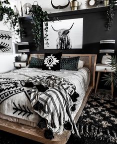 a bed with black and white decor on the wall next to two planters in front of it