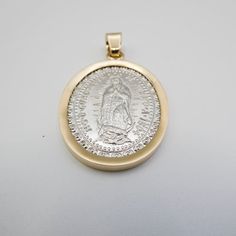 Crafted with solid 14k gold bezel and sterling silver base. Religious image of ‘Nuestra Señora de Guadalupe’ on the front of the medal. Large size allows for easy wearing and outstanding visibility at any distance. Comes in an attractive display box making it an excellent gift idea for religious occasions. Hypoallergenic construction designed to last a lifetime without tarnishing or fading its colors over time. This is a beautiful Medalla de la Viren de Guadaupel. Made from the highest quality s Memorial Miraculous Medal Pendant Jewelry, Anniversary Miraculous Medal Round Pendant Jewelry, Miraculous Medal Pendant For Memorial, Commemorative Gold Jewelry With Large Pendant, Commemorative Coin Pendant Medallion Jewelry, Commemorative Medallion Coin Pendant Jewelry, Gold Large Pendant Jewelry For Commemoration, Oval Spiritual Jewelry For Commemoration, Spiritual Oval Jewelry For Commemoration