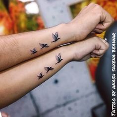 two people with matching tattoos on their arms