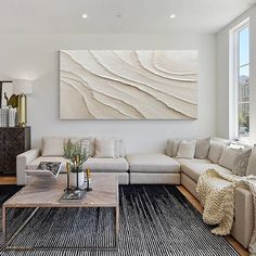 a living room filled with furniture and a painting on the wall