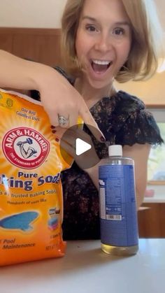 a woman holding a bag of fish food next to a bottle of water and a can