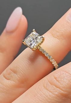 a woman's hand with a yellow and white diamond ring on top of her finger