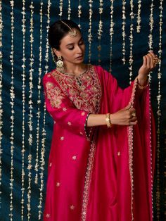 "Jashn-E-Ulfat" - a collection of ensembles that evoke a sense of majestic opulence and modern royalty. Suffused with deep rich hues set on plush cotton silk enhanced with remarkable craftsmanship like Marodi, Mirror and Zardozi embroidery, each ensemble has a romantic and feminine charm of its own collection. This set of 3 consists of a Kurta, Salwar and Dupatta. Kurta: This hot pink chanderi silk kurta is enhanced with handcrafted zardozi, sitara and zardozi jaal work on the neck, buttas on th Elegant Ceremonial Lehenga With Dabka Work, Traditional Chanderi Sets For Formal Occasion, Ceremonial Sharara With Intricate Embroidery For Diwali, Ceremonial Sharara For Diwali With Intricate Embroidery, Silk Sets For Formal Festivals, Silk Sets For Formal Occasions And Festivals, Ceremonial Sharara With Dabka Work, Elegant Dabka Palazzo Set For Festivals, Anarkali Style Ceremonial Sharara With Dabka Work