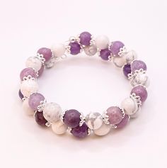 This is a Wire Wrap Beaded Bracelet that adjusts to any size wrist.  Amethyst and White Howlite round beads with Flower silver spacers - Memory Wire Bracelet. This is a Beautiful wrapped Bracelet.  This Bracelet wrap 15 inches in length and is a great piece to add to your jewelry collection. beads are about 8mm. You will receive a nylon gift bag for your gift giving. You will choose gift bag color at checkout. If you have any questions send me a message. Adjustable Lavender Spiritual Bracelets, Adjustable Purple Stretch Bracelet With Natural Stones, Silver Adjustable Crystal Bracelet For Meditation, Silver Amethyst Crystal Bracelet With 8mm Beads, Silver Amethyst Bracelet With 8mm Beads, Adjustable Hand-strung Lavender Bracelet, Adjustable Gemstone Beads Rosary Bracelet, Adjustable Round Crystal Bracelet With Spacer Beads, Adjustable Amethyst Stretch Bracelet With Round Beads