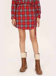 a woman in a red plaid shirt dress and brown boots Winter Cotton Mini Skirt, Winter Mini Cotton Skirt, Red Cotton Skirt For Winter, Cotton Lined Mini Skirt For Winter, Red Pleated Skirt For Fall, Fall Cotton Mini Skirt With Lining, Fall Cotton Lined Mini Skirt, Cotton Lined Mini Skirt For Fall, Winter Cotton Plaid Skirt