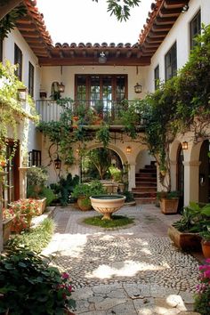 an outdoor courtyard with potted plants and stairs