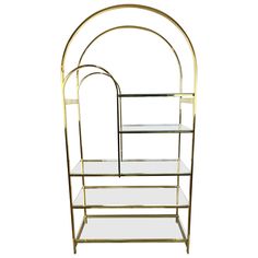 a gold metal shelf with glass shelves on each side and an arched design at the top