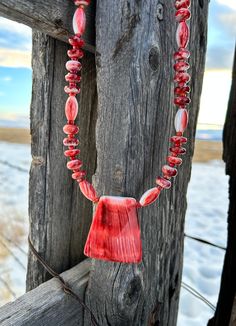 This beautiful necklace was made using a wonderful variety of red spiny oyster shell beads. The spiny oyster pendant is 1 1/2" wide and 2" height Length is 25" $150 Item 744B Artisan Red Jewelry With Large Pendant, Red Coral Pendant Necklace, Handmade Red Shell Necklace Gift, Handmade Red Shell Necklace For Gift, Unique Red Necklace With Large Pendant, Red Bohemian Shell Necklace For Gift, Unique Single Strand Red Beaded Necklace, Unique Red Single Strand Beaded Necklace, Unique Red Single Strand Jewelry