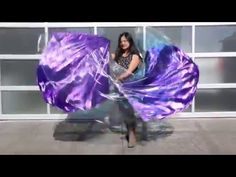 a woman holding a purple umbrella in front of a building