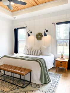 a bedroom with white walls and wood floors