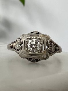 an antique diamond ring sits on a table