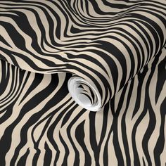 a black and white zebra print wallpaper with a roll of toilet paper on it