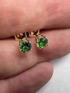 1 carat Tsavorite garnet stud earrings set in 14k yellow gold.  5mm prong set 14k yellow gold green grossular garnet earrings. 1.05 carat, round brilliant cut, 5mm tsavorite grossular green garnets from Kenya. All natural untreated, precision cut, in house, for great brilliance and color. prong set in solid 14k yellow gold. Picture of 5mm prong set next to 4mm bezel set for reference only. 1mm in gemstone size makes a large difference in appearance! See more of our earrings here .  https://www.e Yellow Gold Solitaire Jewelry For May Birthstone, Fine Jewelry Solitaire For May Birthstone, Gemstone Earrings For May Birthstone In Round Cut, May Birthstone Gemstone Earrings With Round Cut, Gemstone Earrings For May Birthstone, Fine Tsavorite Jewelry For Anniversary, Fine Jewelry Earrings For May Birthstone, Yellow Gold Tsavorite Gemstone Earrings, Yellow Gold Tsavorite Earrings As Gift