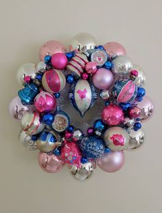 a christmas ornament hanging on the side of a wall with ornaments around it