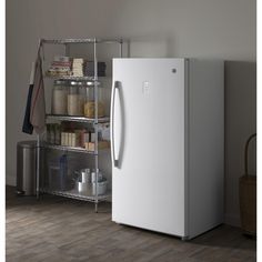 a white refrigerator freezer sitting on top of a wooden floor next to a shelf