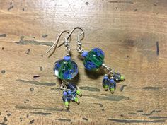 These beautiful handcrafted dangle earrings made of lampwork glass beads drop daintily from a stainless steel ear wire. Handmade Earrings. Made of Blue and Green Flowered Glass Beads, Blue Crystals and Glass Seed Beads dropping from a Stainless Steel Ear Wire. Approx. Full Length (including Ear Wire) is 6 cm / 2.25 in. Approx. Drop Length is 4 cm / 1.50 in. Dispatched in 1-3 business days from Canada. Free Shipping. Whimsical Green Czech Glass Earrings, Bohemian Glass Drop Earrings, Whimsical Czech Glass Drop Earrings, Unique Czech Glass Earrings With Ear Wire, Artisan Green Czech Glass Earrings, Green Beaded Earrings For Celebration, Glass Beaded Drop Earrings, Glass Bead Dangling Drop Earrings, Green Round Bead Earrings For Celebration