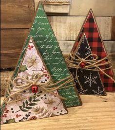 three small christmas trees are sitting on a table