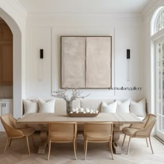 a dining room table with chairs and a large painting hanging on the wall above it