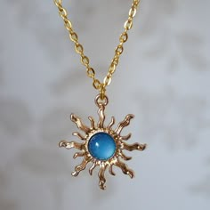 Make a statement with this pretty blue sun drop necklace for women. This cool quirky gold plated and acrylic blue sun necklace is a great way to add a nice touch to your outfit. The charm on this ladies sun necklace measures at 3cm x 2.7cm and is attached to a gold plated chain with lobster clasp. Various lengths of necklace chain are available, please select a length from the drop down menu. Please feel free to get in touch with us at Funky Earrings UK if you have any questions. We also have a wide range of other cute and unusual earrings and necklaces for her in our shop. Blue Sun Aesthetic, Sun Aesthetic Outfit, Blue Accessories Aesthetic, Blue And Gold Aesthetic, Dratini Pokemon, Dnd Jewelry, Blue And Gold Necklace, Blue Gem Necklace, Necklaces For Her