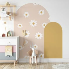 a child's room with flowers painted on the wall and wooden toys in the corner