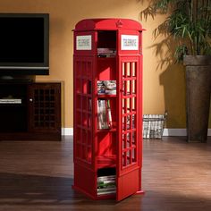 a red phone booth sitting in the middle of a living room next to a tv