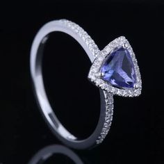 a white gold ring with a pear shaped tanzante and diamonds on the sides