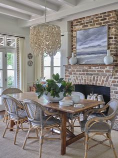 a dining room table with chairs and a chandelier hanging from it's ceiling