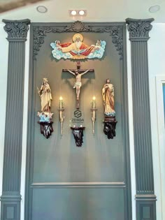 the cross is on display in front of two wall sconces with candles lit