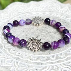 Handmade - This Gorgeous Bracelet Is Made With Smooth Round Purple Agate Beads. The Agate Beads Have Unique Stripes, Patterns, And Hues Of Purple Created By The Minerals That Grew With The Agate In Nature. Large Silver Beads In The Shape Of A Shining Sun Accent The Striped Gemstones. The Two Silver Focals Feature An Etched Celestial Pattern On Both Sides. The Bracelet Is Double Strung For Durability, Stretches For Comfort, And Stacks Well With Other Accessories. Agate Is A Calm Stone That Foster Silver Agate Gemstone Beads Crystal Bracelet, Silver Agate Crystal Bracelet With Gemstone Beads, Silver Crystal Bracelet With Agate Gemstone Beads, Silver Agate Crystal Bracelet As Gift, Silver Agate Crystal Bracelet For Gift, Silver Agate Crystal Bracelet With Round Beads, Symbolic Silver Bracelets With 8mm Beads, Silver Agate Stretch Bracelet Gift, Bohemian Silver Gemstone Beads Stretch Bracelet