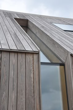 the side of a wooden building with windows on it's sides and wood sidings